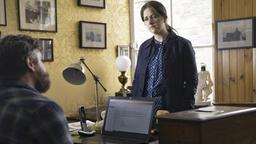 Verleger Jamie Narey (Grant O'Rourke, li.) berichtet Detective Inspector Tosh (Alison O'Donnell, re.) vom Talent des Vermissten.