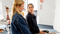 Viola Helmrich (Amelie Kiefer, re.) ist mit ihrem Sohn Linus bei der Kinderärztin (Anja S. Gläser, hinten) und erzählt ihrer Schwester Frederike (Isabel Thierauch) von ihren Problemen.