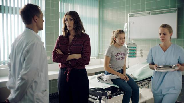 Isy (Milena Tscharntke, sitzend) wird von ihrer besorgten Mutter Bea (Claudia Mehnert, re.) im Krankenhaus abgeholt.