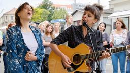 Caroline (Martina Gedeck, links) singt zusammen mit einer Straßenmusikerin (Clara Luzia).