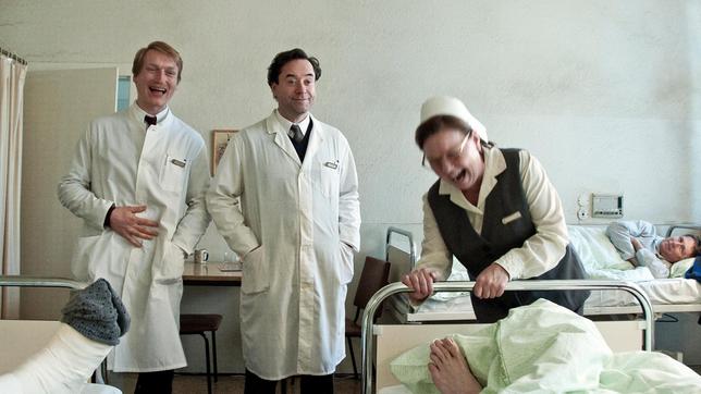 Bild: MDR/teamWorx/Nik Konietzny Chirurg Richard Hoffmann (Jan Josef Liefers), sein Kollege Thomas Wernstein (Christian Sengewald) und Oberschwester Liselotte (Ramona Kunze-Libnow) lachen über einen gelungenen Streich mit Patienten.
