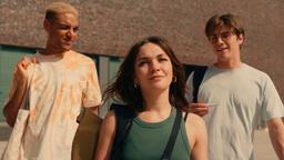 Hannes (Lamin Leroy Gibba), Anna (Emma Drogunova) und Jonas (Gustav Schmidt) witzeln beim Verlassen des Campus miteinander.