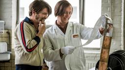 Jochen (Philipp Manuel Rothkopf, l) schaut mit einem Kollegen frisch vergrößerte Erotikfotos.