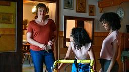 Melanie (Annett Sawallisch) freut sich mit Makeda (Martha Fessehatzion) über Ayanas (Maïmouna Mbacke) neues Fahrrad.