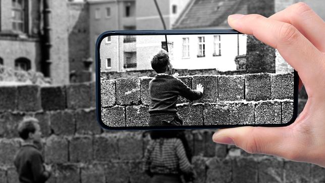 Kinder schauen über die Berliner Mauer