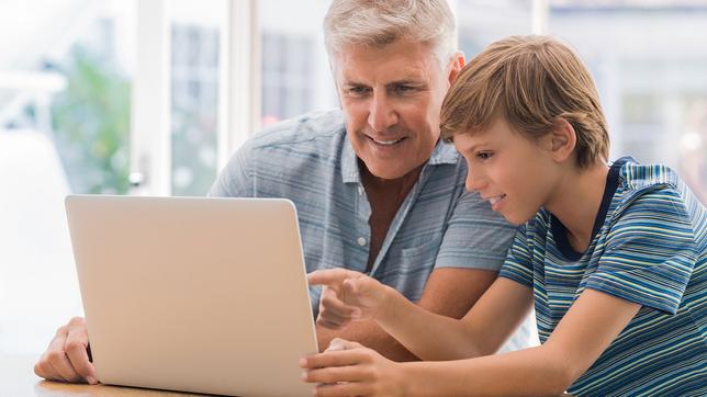 Vater und Sohn sitzen vor Laptop