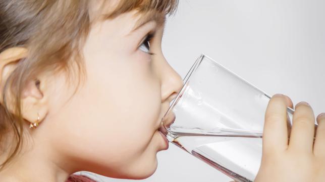 Ein Kind trinkt aus einem Wasserglas