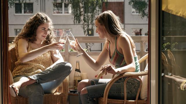 Valli (Amy Benkenstein) und Sandra (Hanna Hilsdorf) trinken Prosecco auf dem Balkon und plaudern. (v.l.)