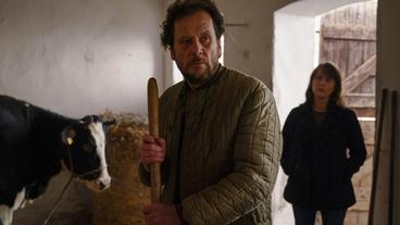 Bild: MDR/filmpool fiction/Stefan Erhard Werner (Christian Kuchenbuch) fütttert die Kühe; Brasch (Claudia Michelsen) erzählt ihm, dass Marie lebt.