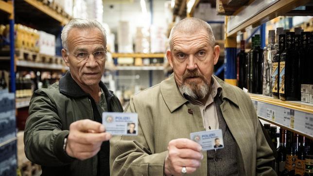 Bild: WDR/Bavaria Fiction GmbH/Martin Valentin Menke Bei Feinkost Raschke: Die Kommissare Max Ballauf (Klaus J. Behrendt, l) und Freddy Schenk (Dietmar Bär) zeigen ihre Dienstausweise.