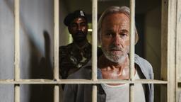 Martin Endler wird von einem Gefängniswärter in seine Zelle geführt.