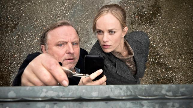 Bild: WDR/Thomas Kost Die Kommissare Frank Thiel (Axel Prahl, l) und Nadeshda Krusenstern (Friederike Kempter, r) machen eine interessante Entdeckung: Dieser Zaun passt zu einem Muster, das sie bereits anderswo gesehen hatten.