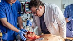 Dr. Friedemann Lech (Till Butterbach) versucht, das Leben des schwer verletzten Andreas Schneider (Nils Bannert) zu retten.