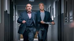 Freddy Schenk (Dietmar Bär, l) und Max Ballauf (Klaus J. Behrendt, r) auf dem Weg ins Büro – das Laptop des Toten haben sie für weitere Untersuchungen dabei.