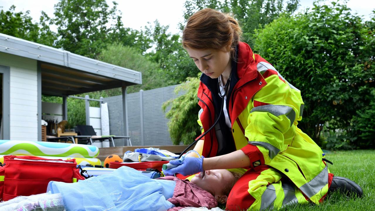 Greta Blaschke (Luise Aschenbrenner) versucht das Leben von Schlüters Tochter zu retten, die keine Luft mehr bekommen hat.