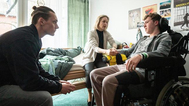 Bild: WDR/Bavaria Fiction GmbH/Thomas Kost Jannik Richter (Linus Moog) ist gelähmt und kann nur schwer sprechen: Jan Pawlak (Rick Okon) befragt ihn trotzdem. Natalja Richter (Valery Tscheplanowa) hält die Hand ihres Sohnes.
