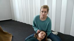 Karin Gorniak (Karin Hanczewski) bricht unter straken Schmerzen zusammen, ihre Kollegin Leo Winkler (Cornelia Gröschel) fängt sie auf