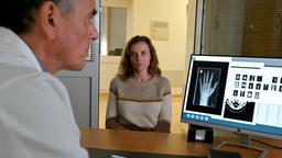 Karin Gorniak (Karin Hanczewski) ist beim Amtsarzt Dr. Herbst (Ahmad Mesgarha) um eine Ursache für ihre Schmerzen zu finden