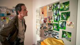 Kommissar Peter Faber (Jörg Hartmann) betrachtet in der Wohnung eines Verdächtigen Fotos, die ihn eindeutig mit den Morden in Verbindung bringen.