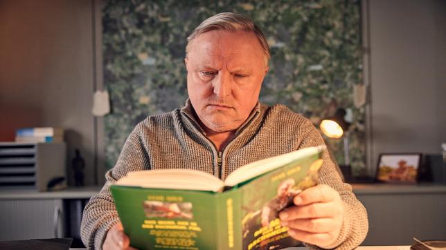 Bild: WDR/Frank Dicks Kommissar Thiel (Axel Prahl) will Hottes Geschichten näher auf den Grund gehen und liest das Buch, dass dieser als Stand Gold veröffentlicht hat :"Der Mann, der in den Dschungel fiel".