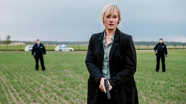 Bild: WDR/unafilm GmbH/Elliott Kreyenberg Kommissarin Martina Bönisch (Anna Schudt) mit Streifenbeamten bei einer Verfolgung auf einem Feld.