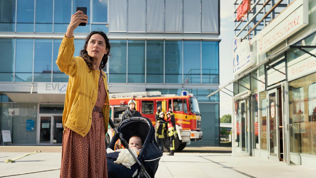 Nathalie Köhler (Sotiria Loucopoulos) ist eine junge Mutter, die in der Gerbersiedlung lebt und die Löscharbeiten beobachtet - Fotos davon postet sie im Internet.