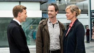 Bild: WDR/Bavaria Fiction GmbH/Martin Menke Nils Jacob (Franz Pätzold, links) ist Nachwuchspolitiker - und weiß, wie er mit populistischen Äußerungen in Sozialen Netzwerken punkten kann. Nach dem Mord in der Gerbersiedlung spricht er auch mit Kommissarin Martina Bönisch (Anna Schudt, rechts) und Kommissar Peter Faber (Jörg Hartmann, Mitte).
