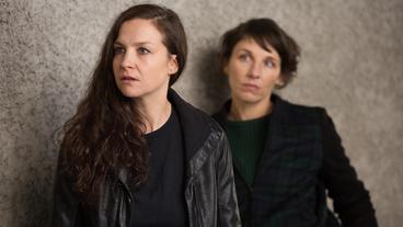 TATORT: Nina Rubin (Meret Becker) beobachtet, wie Karow die Halterin des Täterfahrzeugs Birgit Hahne (Valerie Koch) vernimmt.