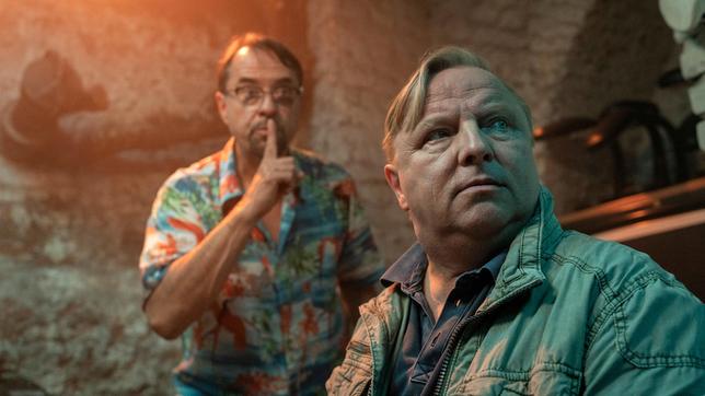 Bild: WDR/Bavaria Fiction GmbH/Thomas Kost Prof. Karl-Friedrich Boerne (Jan Josef Liefers) und Kommissar Axel Thiel (Axel Prahl) hören aus Ihrem Versteck im Keller, wie sich Frau Mann und Herr Muster auf ihrer Suche immer weiter vorarbeiten.