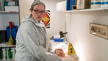 Bild: WDR/Thomas Kost Rechtsmedizinerin Greta Leitner (Sybille J. Schedwill, links) untersucht das Todesopfer am Tatort: Dr. Gisela Monheim (Ivonne Reifenrath, liegend) starb im Ruheraum der Notfallambulanz.