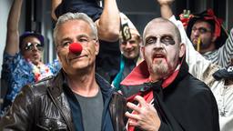 Auch im Präsidium wird Karneval gefeiert: Kommissar Freddy Schenk (Dietmar Bärr) geht als Vampir, während sein Kollege Max Ballauf (Klaus J. Behrendt) nur widerwillig die Pappnase trägt.