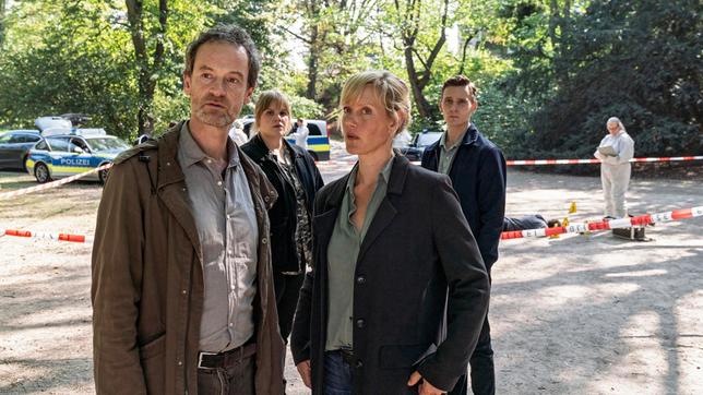 Tatort im Park: Ein Polizist wurde getötet – die Kommissare Peter Faber (Jörg Hartmann), Rosa Herzog (Stefanie Reinsperger), Martina Bönisch (Anna Schudt) und Jan Pawlak (Rick Okon) schauen sich um, während Rechtsmedizinerin hinten rechts) das Opfer untersucht.