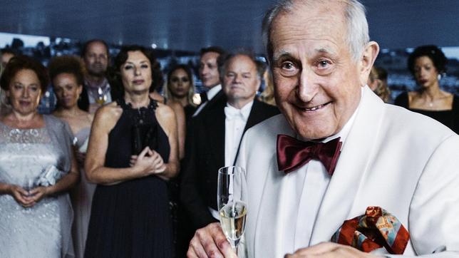 Bild: SRF/Hugofilm Will Gutes tun: Walter Loving (Hans Hollmann) begrüsst die VIP-Gäste zum Benefizkonzert. Im Bildhintergrund: Die Pianistin Miriam Goldstein (Teresa Harder), der Dirigent Gidon Winternitz (Gottfried Breitfuss) und die Konzertorganisatorin Silvia Bosshardt (Heidi Maria Glössner).