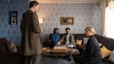 Bild: WDR/Bavaria Fiction GmbH/Martin Menke Wo steckt ihr Sohn Hakim? Das wollen oder können Abdul Azim Khaled (Ferhat Keskin) und seine Frau Rana Khaled (Meryem Moutaoukkil) den Kommissar*innen Martina Bönisch (Anna Schudt, rechts) und Peter Faber (Jörg Hartmann, links) bei der Befragung im Wohnzimmer der Familie nicht verraten.