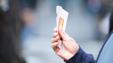 Bild: photos.com Eine Person hält Tickets in der Hand