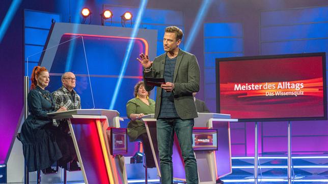 Bereit zum Mitraten? Beim Wissensquiz "Meister des Alltags" begrüßt Gastgeber Florian (Mitte) seine prominent besetzten Rateteams. Zu sehen sind (v. li.) Moderatorin Enie van de Meiklokjes und Telefonschreck Bodo Bach sowie Comedienne Meltem Kaptan. Den Gewinn spendet "Meister des Alltags" einem guten Zweck.