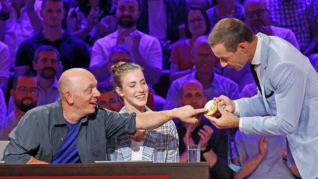 Bild: ARD/Morris Mac Matzen Moderator Kai Pflaume mit Rateteam-Kapitän Bernhard Hoëcker und der Gymnastin und Olympia-Goldmedaillengewinnerin Darja Varfolomeev.