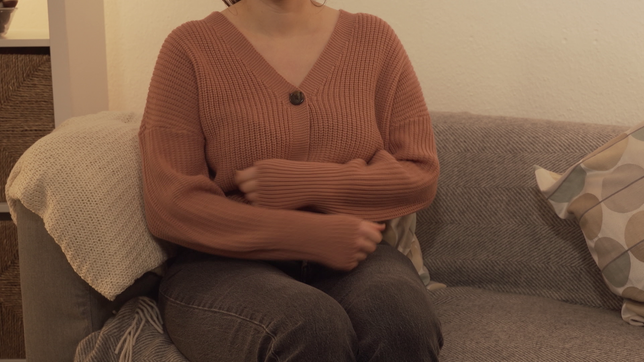 Frau legt Arme auf den Bauch