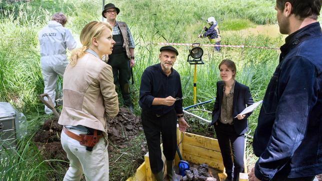 Bild: ARD/Andreas Wünschirs AKTE EX: Am Fundort Kristina Katzer (Isabell Gerschke) , Schatzsucher (Thorsten Giese, im HG), Museumsdirektor Professor Paul Winter (Alexander Radszun) mit Assistentin Jasmin Brand (Luise Helm) und Lukas Hundt (Oliver Franck).