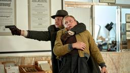Heimann (Moritz Führmann) nimmt Wolfgang Berns (Max Riemelt) als Geisel, um aus dem Postamt zu fliehen.