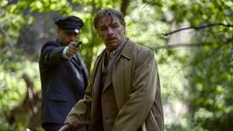 Wolfgang Berns (Max Riemelt) bedroht Alois Brunner (André Eisermann) im Wald mit einer Waffe.