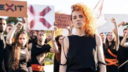 Demonstrantin Mine (Inês Heredia) zusammen mit den Protestler:innen am Eingang der Charité.