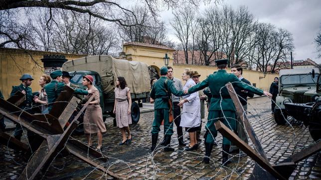 Vor der Charité wird eine Mauer errichtet - Soldaten halten Passanten zurück.