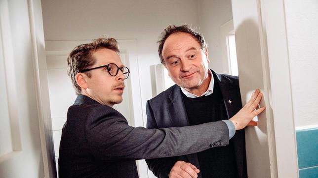 Bild: BR/Nadya Jakobs Pfarrer Brandl empfängt den Generalvikar, nachdem er den „tauchenden“ Florian im Bad übersehen hat. Von links: Pfarrer Simon Brandl (Ferndinand Schmidt-Modrow) und Generalvikar Kaiser (Pfarrer Rainer Maria Schießler). Weiteres Bildmaterial finden Sie unter www.br-foto.de.