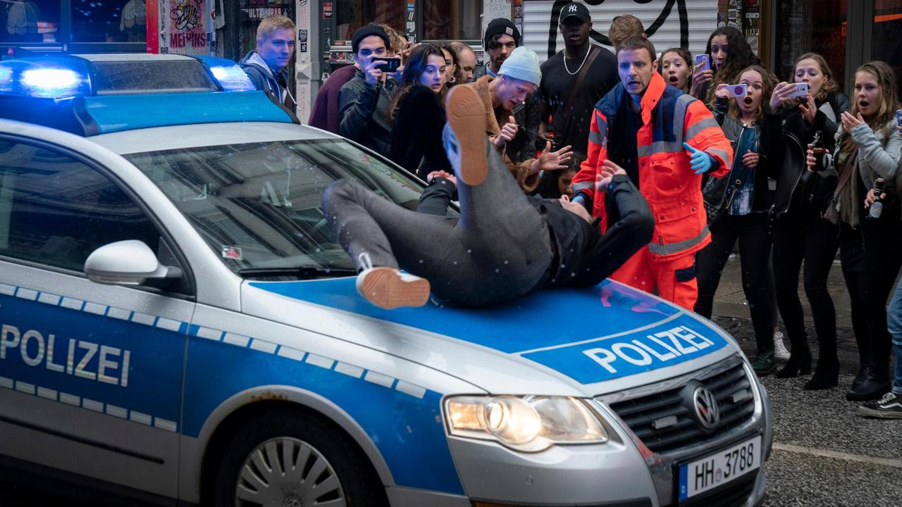 Rettungseinsatz: Entsetzt sieht Sanitäter Manfred Liebert (Jonas Minthe), dass ein Passant von einem Polizeiwagen erfasst wird. Gaffer fotografieren alles mit dem Handy.