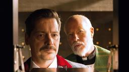 Falk (Fritz Karl) steht mit dem Pfarrer (Bill Mockridge)) in der Grabeskirche vor den Urnenkästen und siniert darüber, was nach dem Tod kommt.
