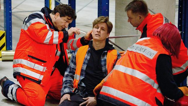 Christian (Francis Fulton-Smith) ist als Notarzt vor Ort: Boris Kehr (Jürgen Klein) wurde von einer herabfallenden Pallette verletzt (mit Komparsen).