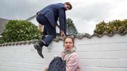 Frank Weber (Sebastian Schwarz) klettert über die Gartenmauer, Carla (Meike Droste) steht Schmiere.