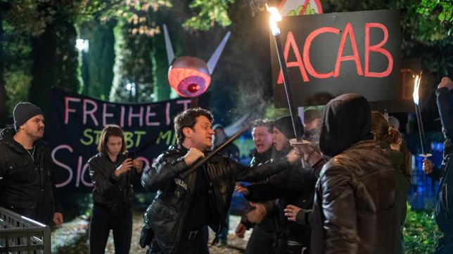 Bild: ARD/Thorsten Jander Die Situation eskaliert: Es kommt zu einem tätlichen Übergriff zwischen Daniel Schirmer (Sven Fricke) und einigen Demonstranten (Kompars:innen).