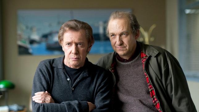 Bild: ARD/Thorsten Jander Lothar Krüger (Peter Heinrich Brix) traut seinen Ohren nicht. Seine Lebensgefährtin gesteht beim Verhör, dass sie seit 20 Jahren mit dem Rocker Dizzy Eisenbraun verheiratet ist. Dirk Matthies (Jan Fedder) weiß, was diese Aussage für seinen ehemaligen Kollegen bedeutet.
